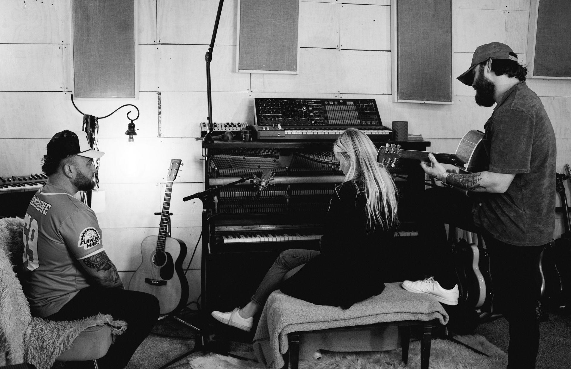 James and Katie Talbot, co-founders of Gold Lion Studios, sitting in their Nashville recording studio, surrounded by professional audio equipment, representing their passion for artist development and music production.